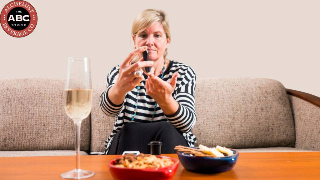 Woman monitoring diabetes while enjoying wine with snacks
