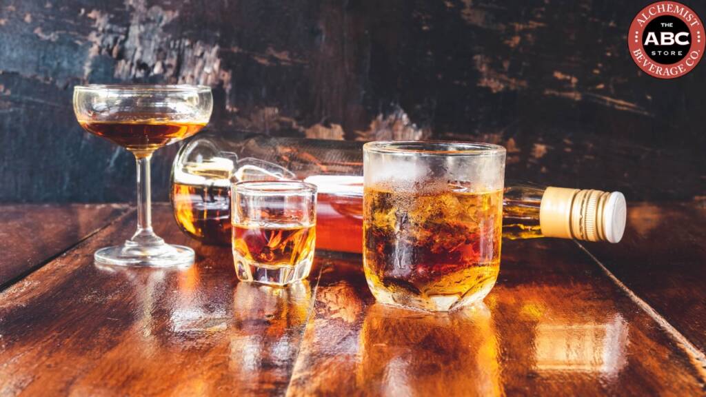 Glasses of liquor and a bottle on a wooden table